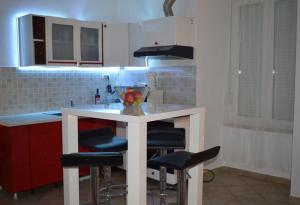 una cocina con una isla blanca con taburetes de bar en Apartments with WiFi Rijeka - 13882, en Rijeka