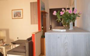 una sala de estar con un jarrón de flores rosas sobre una mesa en Apartments with WiFi Rijeka - 13882, en Rijeka