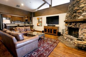a living room with leather furniture and a stone fireplace at Bald Eagle Two Bedroom apartment hotel in Park City