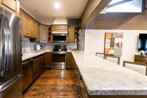 a large kitchen with wooden cabinets and stainless steel appliances at Bald Eagle Two Bedroom apartment hotel in Park City