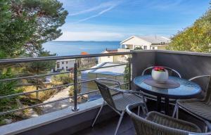 stół i krzesła na balkonie z widokiem na ocean w obiekcie Seaside apartments with a swimming pool Krilo Jesenice, Omis - 13898 w mieście Jesenice