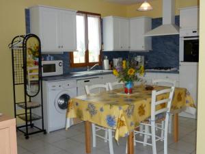 a kitchen with a table with a yellow table cloth at Maison charmante avec terrasse, jardin clos et animaux acceptés - FR-1-616-90 in Saint-Martin-de-Ribérac
