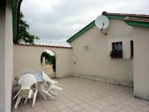 a patio with chairs and a table and a building at Maison charmante avec terrasse, jardin clos et animaux acceptés - FR-1-616-90 in Saint-Martin-de-Ribérac