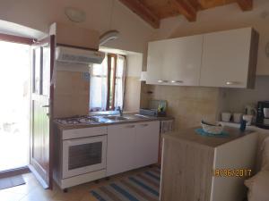 a kitchen with white cabinets and a stove top oven at Secluded house with a parking space Beli, Cres - 13893 in Beli