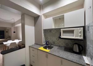 a kitchen with a sink and a microwave at Oro Centro Suites in San Miguel de Tucumán