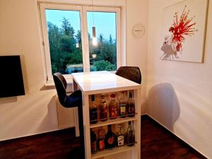 a bar with alcohol bottles on a shelf in front of a window at KARINO helles Apartment über den Havel-Gärten auf der Dominsel in Brandenburg an der Havel