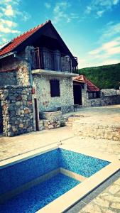 ein Haus mit einem Pool vor einem Gebäude in der Unterkunft Family friendly house with a swimming pool Zagvozd, Zagora - 13901 in Zagvozd