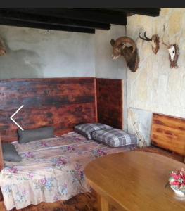 ein Schlafzimmer mit einem Bett und einem Tisch und Hörnern an der Wand in der Unterkunft Family friendly house with a swimming pool Zagvozd, Zagora - 13901 in Zagvozd