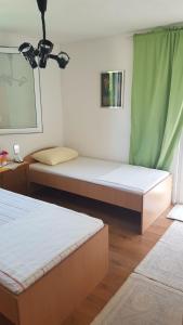 two beds in a room with green curtains at Apartments with a parking space Rudina, Hvar - 13903 in Stari Grad