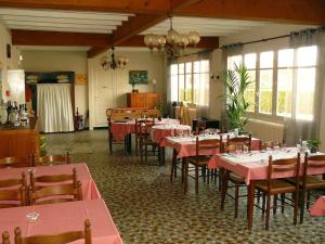 ein Restaurant mit rosa Tischen und Stühlen in einem Zimmer in der Unterkunft Auberge Fleurie in Saint-Nizier-sur-Arroux