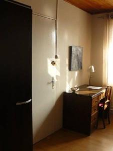 Zimmer mit einem Schreibtisch und einem Tisch mit einer Lampe in der Unterkunft Auberge Fleurie in Saint-Nizier-sur-Arroux