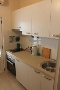 a kitchen with white cabinets and a sink at Apartments by the sea Cove Vela Stiniva, Hvar - 13935 in Zastražišće
