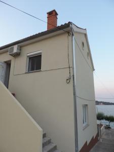 ein weißes Haus mit Treppen, die zu ihm führen in der Unterkunft Apartments by the sea Kali, Ugljan - 13865 in Kali