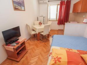 une petite pièce avec un lit et une table avec une télévision dans l'établissement Apartments by the sea Tucepi, Makarska - 13955, à Tučepi