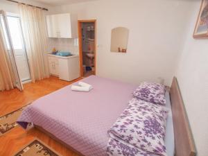 une chambre avec un lit avec une couette violette dans l'établissement Apartments by the sea Tucepi, Makarska - 13955, à Tučepi