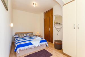 a bedroom with a bed with a blue and white striped blanket at Apartments with WiFi Split - 13957 in Split