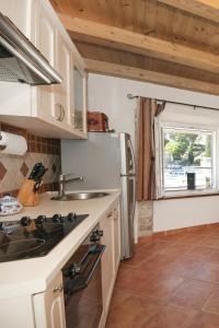 a kitchen with a stainless steel refrigerator and a window at Seaside holiday house Maslinica, Solta - 13965 in Grohote