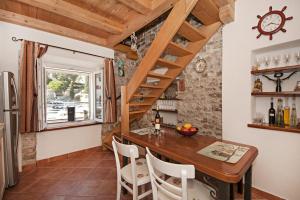 una cucina e una sala da pranzo con tavolo in legno di Seaside holiday house Maslinica, Solta - 13965 a Grohote