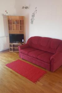 un divano rosso in soggiorno con tappeto rosso di Apartments with a parking space Vodice - 13997 a Vodice