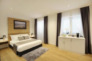 a bedroom with a bed and a desk and windows at Rooms by the sea Zadar - 14007 in Zadar