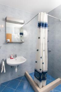 a bathroom with a shower curtain and a sink at Apartments and rooms by the sea Lopud, Elafiti - 14013 in Lopud Island