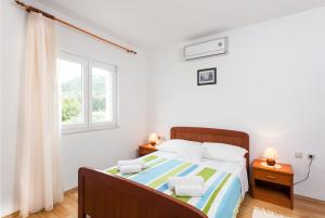 a bedroom with a bed with two night stands and two windows at Apartments and rooms by the sea Lopud, Elafiti - 14013 in Lopud Island