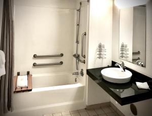 a white bathroom with a sink and a shower at Travelodge by Wyndham Madison Heights MI in Madison Heights