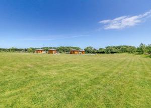 a large green field with houses in the distance at Green Meadows Park in Garton