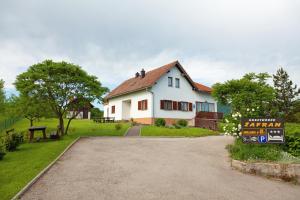 a white house with a sign in front of it at Double Room Smoljanac 14023b in Smoljanac