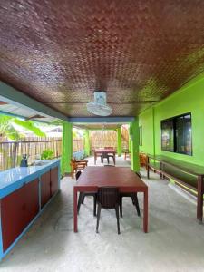 a patio with a wooden table and green walls at Selim Guesthouse in San Vicente