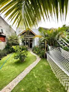 a house with a yard with grass and a fence at BinhYen Homestay in Mui Ne