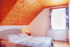 a bedroom with a bed and a wooden ceiling at Apartments and rooms with parking space Smoljanac, Plitvice - 14023 in Smoljanac