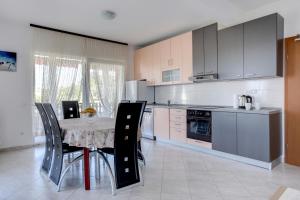 a kitchen with a table and some chairs in a room at Family friendly apartments with a swimming pool Kastel Sucurac, Kastela - 14047 in Kaštela