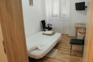 a small bedroom with a bed and a chair at Apartments with WiFi Rijeka - 14061 in Rijeka