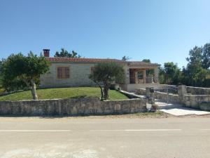 a house with a stone wall in front of it at Family friendly house with a swimming pool Popovici, Zagora - 14074 in Benkovac