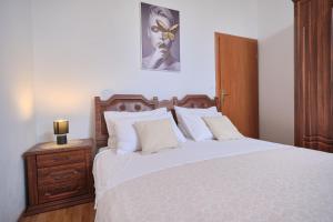 una camera da letto con un grande letto bianco con testiera in legno di House Roza a Podstrana