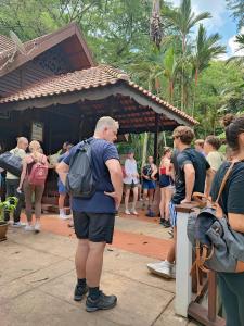 Un uomo in piedi di fronte a una folla di persone di Tekoma Resort Taman Negara a Kuala Tahan