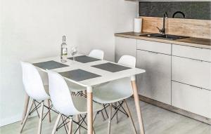 a kitchen with a white table and white chairs at Amazing Apartment In Mrzezyno With Wifi in Mrzeżyno