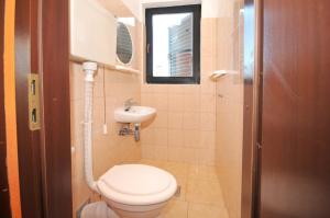 łazienka z toaletą, umywalką i oknem w obiekcie Apartments with a parking space Okrug Donji, Ciovo - 13732 w mieście Okrug Donji +23 zdjęcia