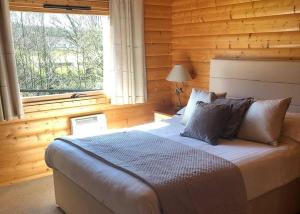 a bedroom with a large bed with a window at Fingle Glen Lodges in Whitestone