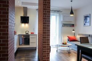 eine Küche und ein Wohnzimmer mit einer Ziegelwand in der Unterkunft Apartamenty Starówka - Riverside in Stettin