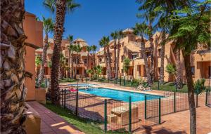 basen z palmami i budynkami w obiekcie Awesome Apartment In Los Alcázares w mieście Los Alcázares