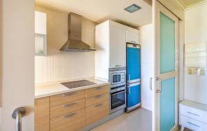 kuchnia z białymi szafkami i niebieskimi urządzeniami w obiekcie Awesome Apartment In Los Alcázares w mieście Los Alcázares