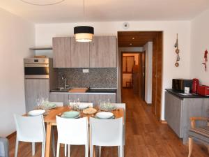 eine Küche und ein Esszimmer mit einem Holztisch und Stühlen in der Unterkunft Appartement Montgenèvre, 2 pièces, 6 personnes - FR-1-266-190 in Montgenèvre