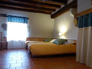 ein Schlafzimmer mit einem Bett mit gelber Bettwäsche und einem Fenster in der Unterkunft Gîte Lurcy-Lévis, 5 pièces, 10 personnes - FR-1-489-392 in Lurcy-Lévis