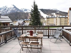 einen Tisch und Stühle auf einem Balkon mit schneebedeckten Bergen in der Unterkunft Appartement Montgenèvre, 2 pièces, 6 personnes - FR-1-266-190 in Montgenèvre