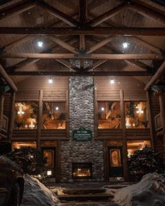 a building with a stone fireplace in the snow at New England Inn & Lodge in North Conway