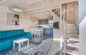 Nice Home In Sianozety With Kitchen في سيانوزيتي: غرفة معيشة مع أريكة زرقاء ومطبخ