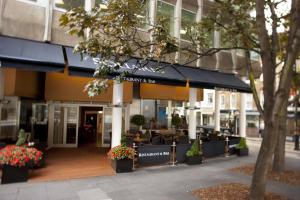 a building with a restaurant with tables and flowers at Thistle Trafalgar - Leicester Square in London