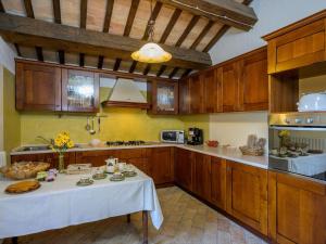 una grande cucina con tavolo al centro di Elegant Stone House w Pool a Monte San Martino
